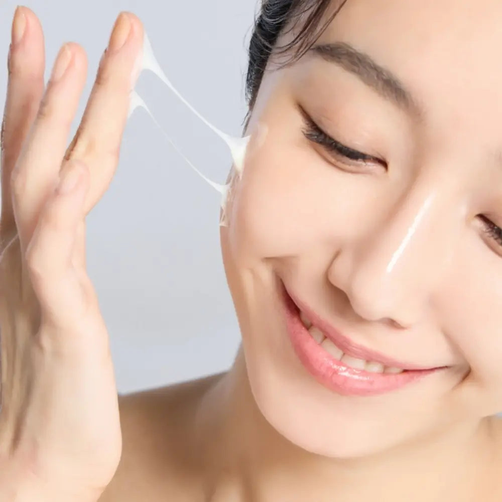 Woman touching smooth, moisturized-looking skin after applying Korean repair cream