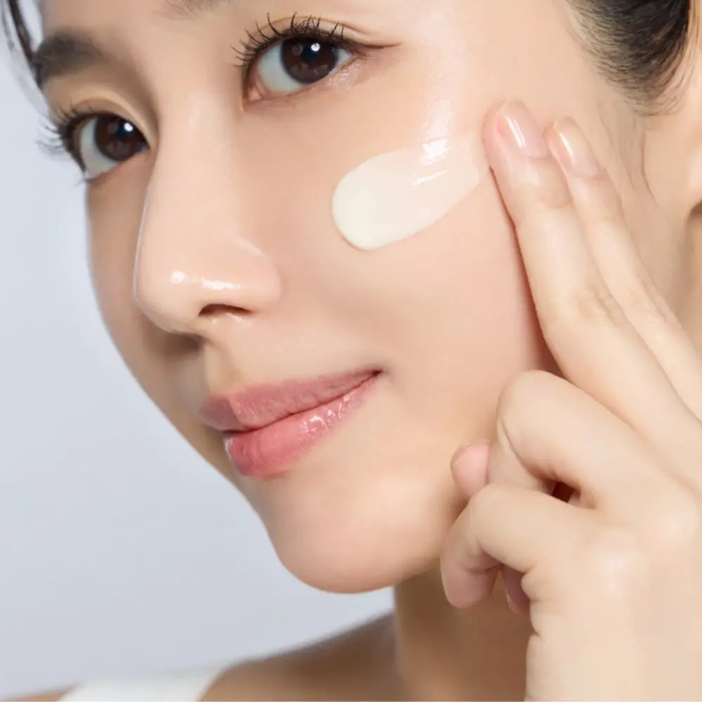 Korean woman applying INCELLA Derma Silk Heartleaf PDRN Cream to her cheek